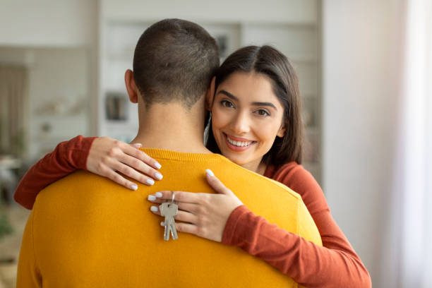 istock Couple hugging, woman showing keys 2155548008