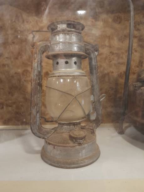 istock An old metal mining lamp on a white shelf and a brown wall 2155550090