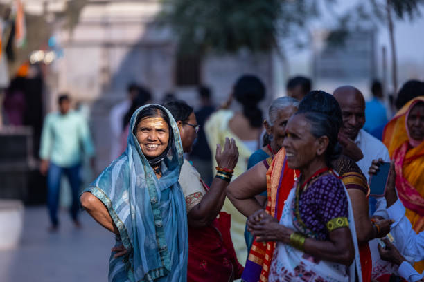 Varanasi, Uttar Pradesh, India - March 2023: Portrait on an old indian marathi woman in traditional saree at holy ghats near river ganga in varanasi to perform hindu rituals.