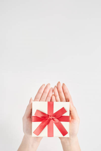 A woman's hand holds a box wrapped for a gift