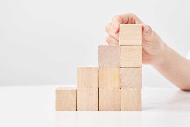 istock Hands of a woman stacking wooden blocks 2155552448