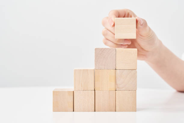 istock Hands of a woman stacking wooden blocks 2155552482