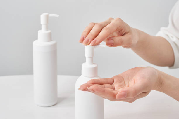 istock white bottle and woman's hand 2155552557