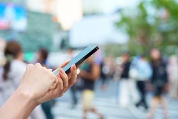 istock a woman operating a smartphone in a downtown area 2155553165
