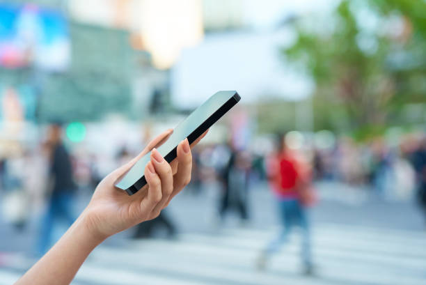 istock a woman operating a smartphone in a downtown area 2155553183