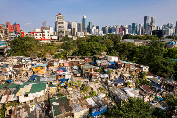 Metro Manila - A squatter colony contrasts with the modern BGC skyline. Concept of inequality. Metro Manila, Philippines - April 2023: A squatter colony contrasts with the modern BGC skyline. Concept of inequality. run down neighborhood stock pictures, royalty-free photos & images