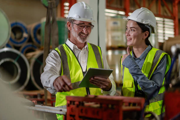 istock Industrial engineer team standing in manufacturing facility talking machinery maintenance in heavy industry 2155558942