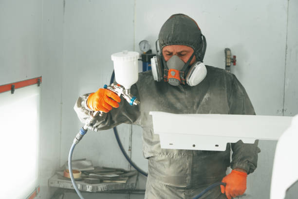 istock Auto painter painting a car with vaporizer gun inside a paint booth 2155559196