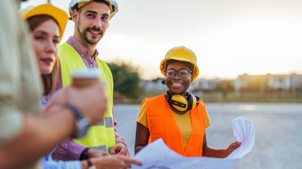 istock Diverse Team of Construction Workers Reviewing Blueprints 2155559279