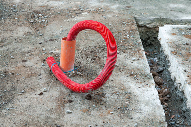 istock Laying communications in the ground using red corrugated hoses. 2155561840