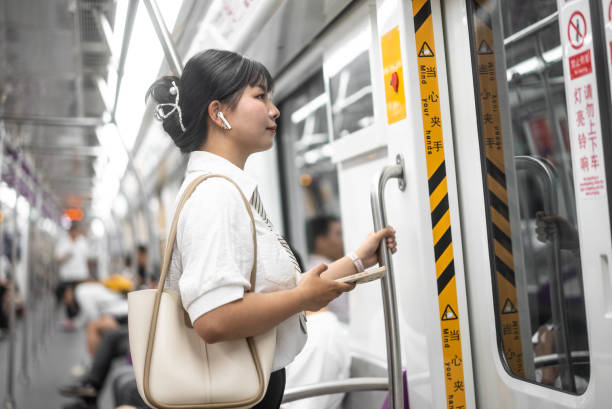 istock asian female using smart phone in subway 2155563994