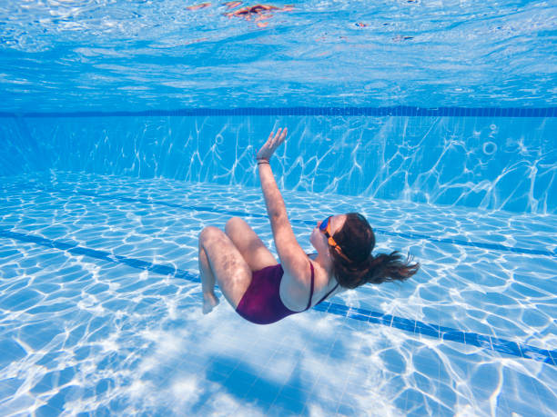 istock Little girl having fun swimming underwater 2155568356
