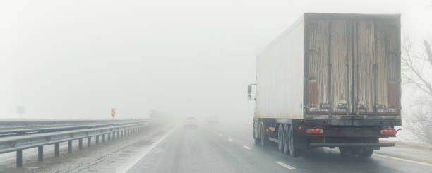 Driver POV on traffic on blue foggy misty rainy slush highway intercity road with low poor visibility on cold winter autumn morning. Seasonal bad rainy weather accident danger warning. car fog light Driver POV on traffic on blue foggy misty rainy slush highway intercity road with low poor visibility on cold winter autumn morning. Seasonal bad rainy weather accident danger warning. car fog light. truck rain stock pictures, royalty-free photos & images
