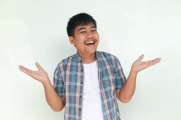 istock Young Asian man pointing finger to empty space beside him. 2155568984