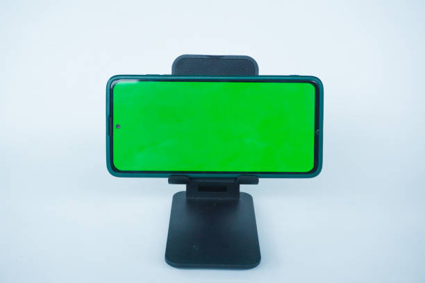 Phone with hole punch placed in stand showing green screen