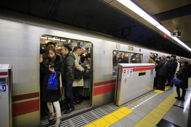 crowd of commuters in tokyo Tokyo Japan-21 january 2018: passenger wait in the toel oedo line subway station. toel oedo line subway is one oof busy subway in japan muster station stock pictures, royalty-free photos & images