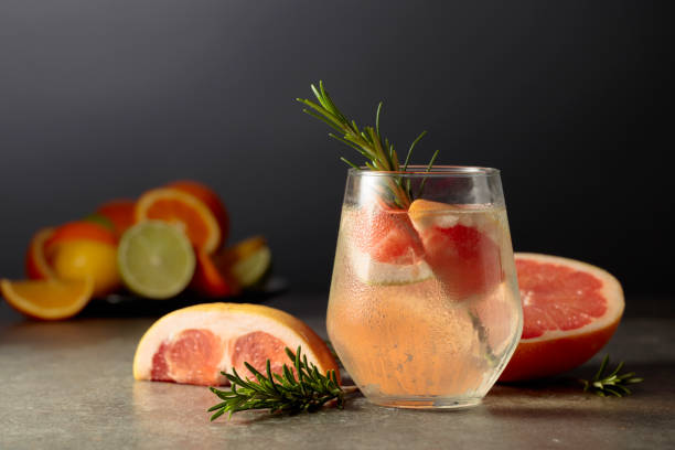istock Cocktail gin tonic with ice, rosemary, and grapefruit on a stone table. 2155574978