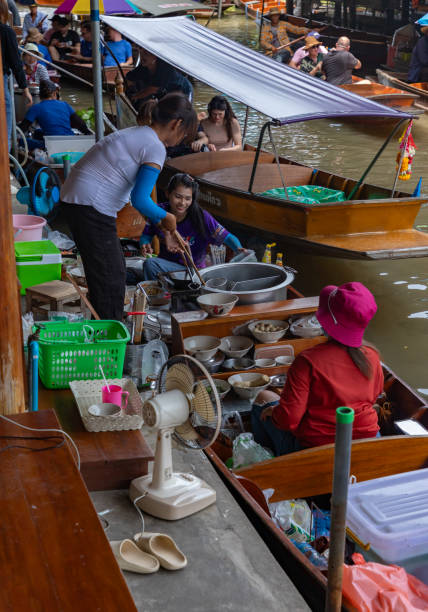 Damnoen Saduak, Thailand - Thai lady selling food, drink and ice cream from a boat at Damnoen Saduak floating market