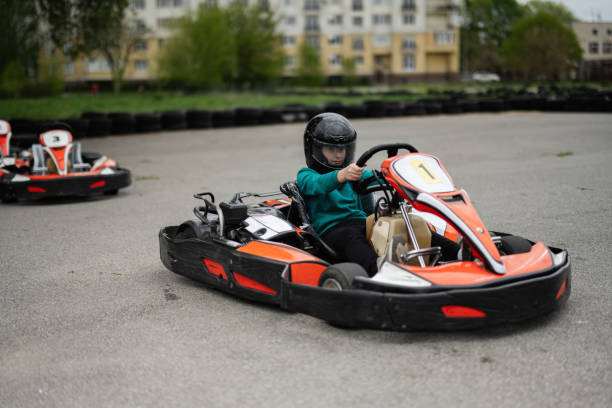 Young woman in helmet focused on the race, sitting in a go-kart ready for action.