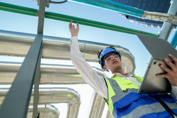 istock Industrial engineer adjusting pipeline valve with radio communication on construction site. Engineer on urban construction site using radio to coordinate with team on a sunny industrial rooftop. 2155584465