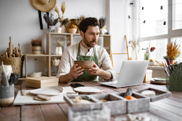istock Adult ceramic shop owner using laptop while working in store. 2155589048