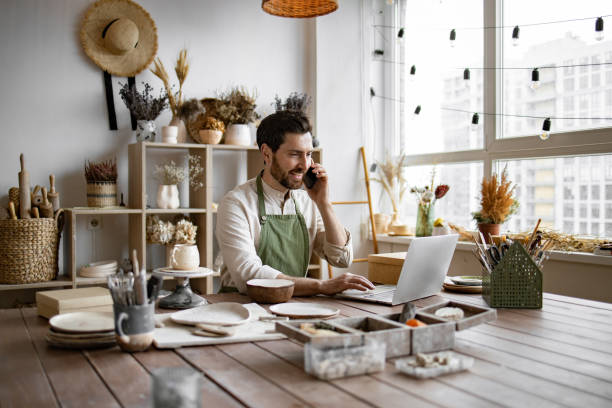 istock Experienced potter places online order while talking to customer over phone. 2155589092