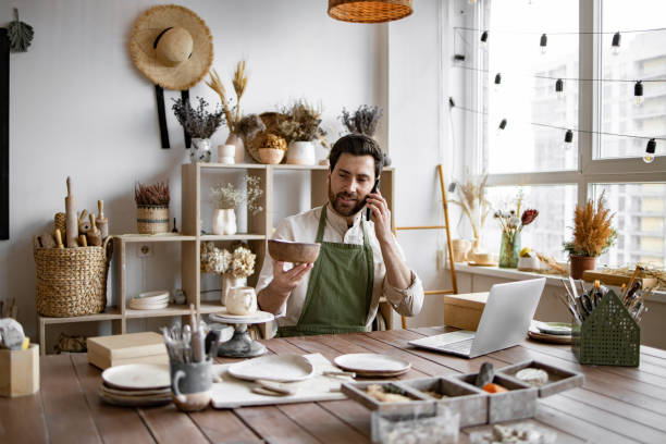 istock Experienced potter places online order while talking to customer over phone. 2155589098
