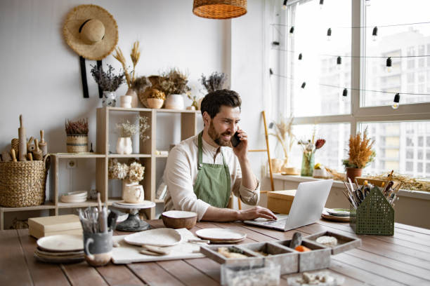 istock Experienced potter places online order while talking to customer over phone. 2155589103