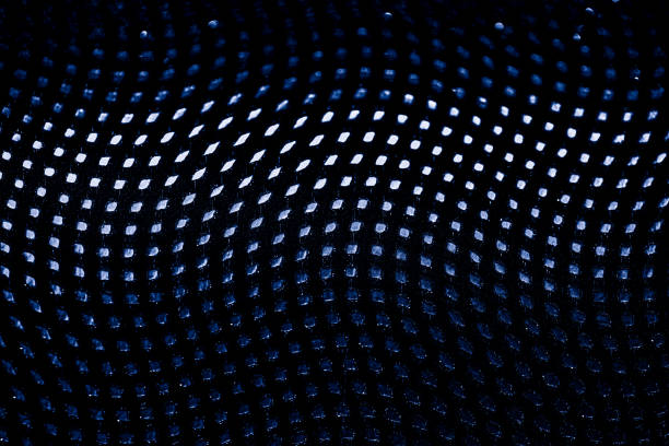 Blue neon curved wave of light as curls, swirl or spiral with dotted stripes on black background, pattern. Abstract background with motion light effect, light painting in holiday style.
