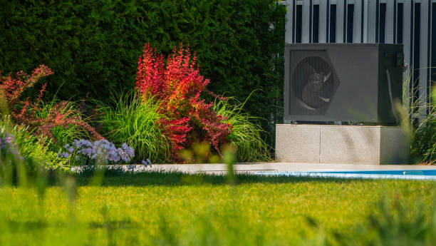 istock Heat pump unit next to a pool with surrounding ornamental plants. 2155589644