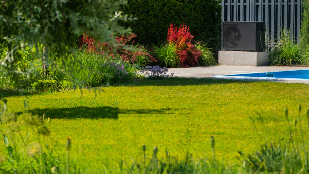 istock Heat pump unit next to a pool with surrounding ornamental plants. 2155590402