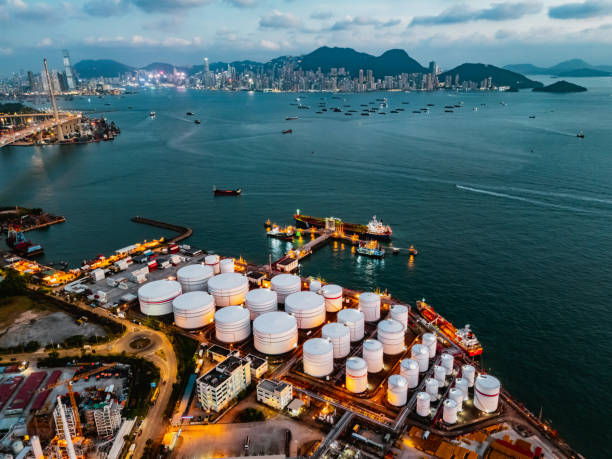 tank ship loading unloading oil and gasoline at commercial dock in sea - gáz témájú stock jellegű vizuális alkotások, jogdíjmentes fotók és képek