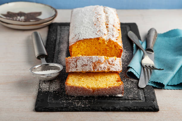 istock Orange fruit cake. Cake. Pound Cake. Traditional vanilla pound cake with orange. Orange loaf cake sliced on board. 2155593490