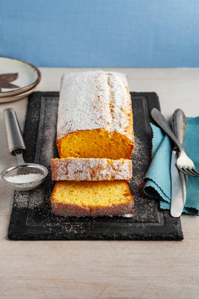 istock Orange fruit cake. Cake. Pound Cake. Traditional vanilla pound cake with orange. Orange loaf cake sliced on board. 2155594607