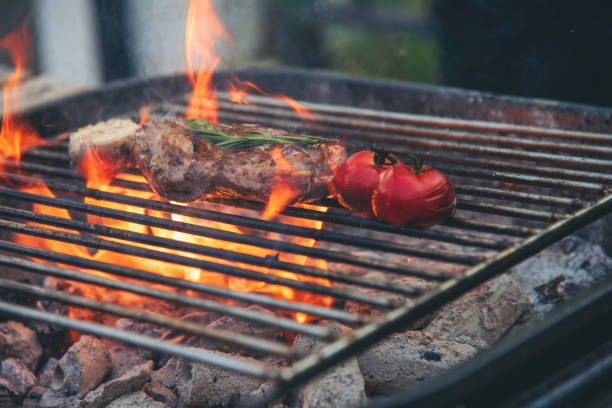 istock BBQ Barbecue grilled meat stick on fire flame with hot charcoal cooking outside. Beef grilling picnic outdoor with smoke bacon spicy sausage for party. Grill pork bbq on fire flame 2155597082