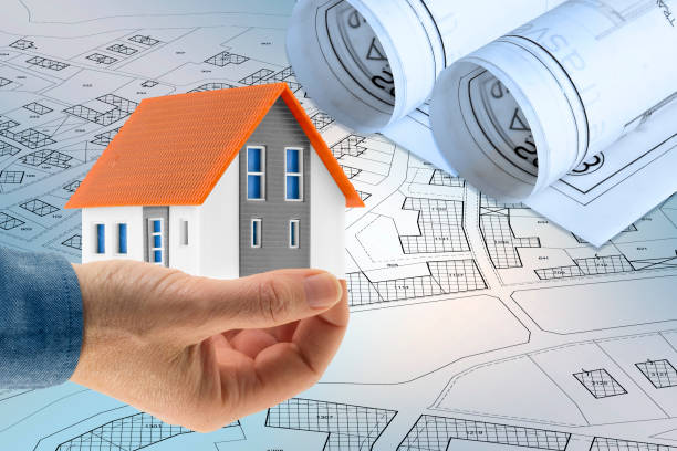 istock Building activity and construction industry concept  with home model against an imaginary cadastral map 2155598616
