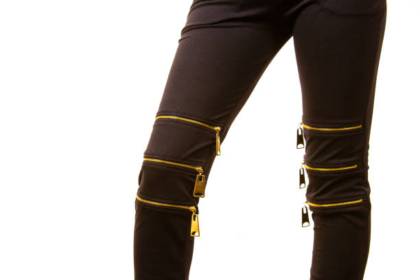 Unrecognizable fashionable woman wearing black skinny slim jeans with many zipper fasteners, grunge hipster style outfit detail.