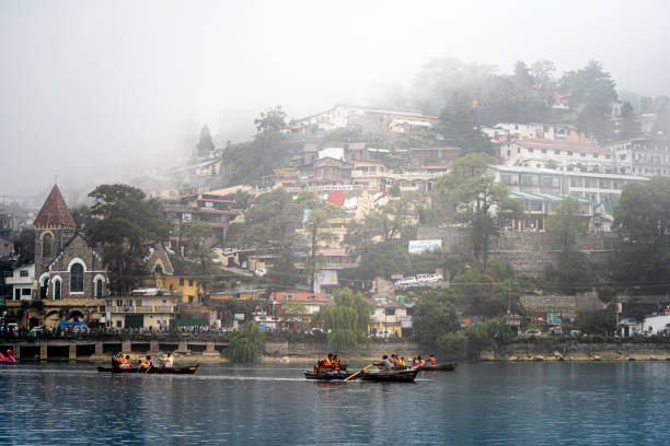 boats on blue waters, colorful buildings and rolling fog from the lake of nainital a popular hill station in uttarakhand india - nainital photos et images de collection