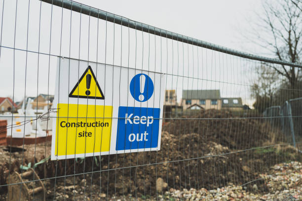 istock Shallow focus on typical Keep Out and Construction Site signs attached to temporary metal fencing. 2155599744