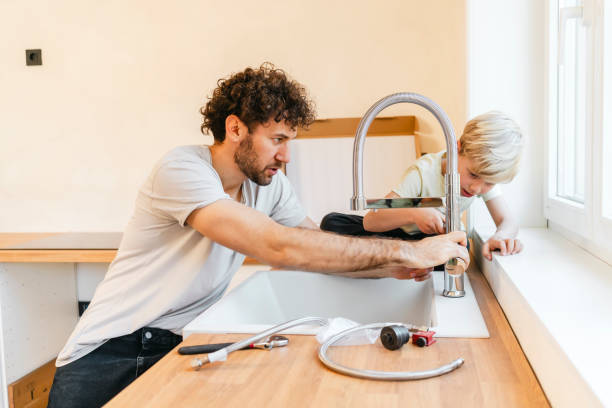 Father and son assembling kitchen furniture stock photo