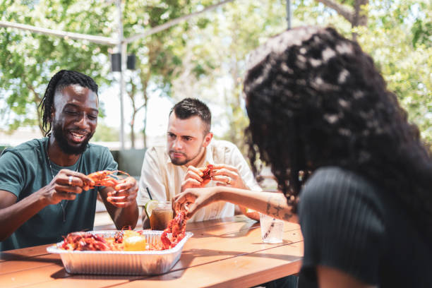 istock Friends enjoying crawfish outdoors at a picnic table in restaurant 2155603605