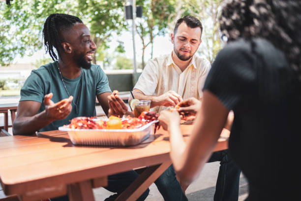 istock Friends enjoying crawfish outdoors at a picnic table in restaurant 2155605521