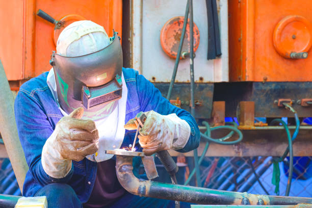A young university student female is practicing her welding skills