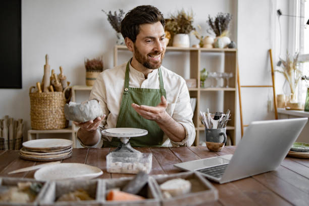 istock Bearded male studying remotely at university sitting in pottery studio. 2155607512