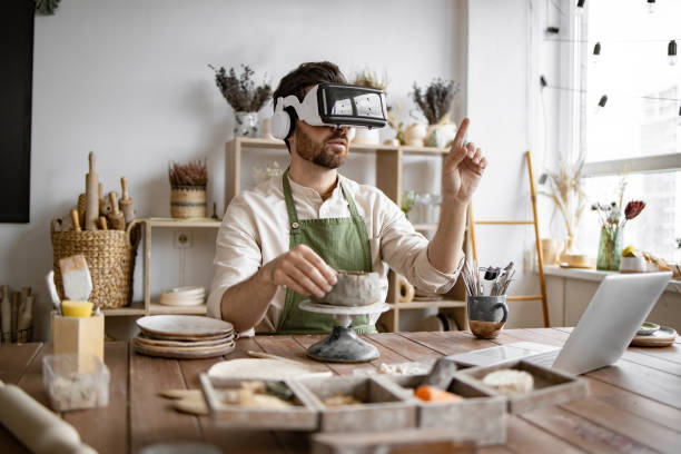 istock Sculptor using virtual reality glasses to create a clay vase 2155607514