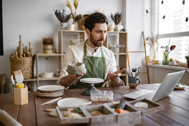 istock Bearded male studying remotely at university sitting in pottery studio. 2155607531