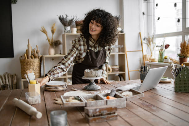 istock Smiling woman with curly hair working in craft studio 2155607532
