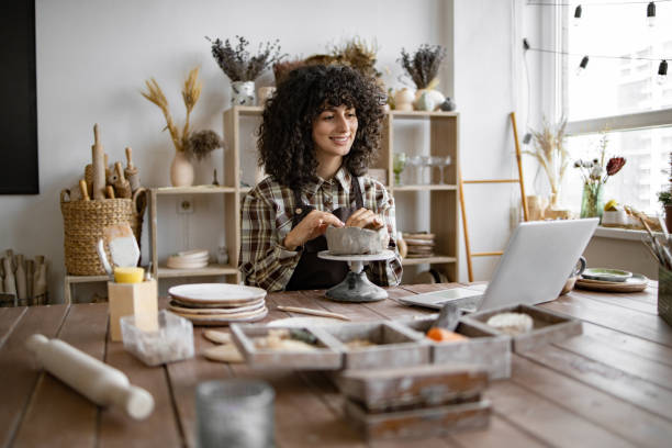 istock Female pottery artist working on clay project in home studio 2155607541