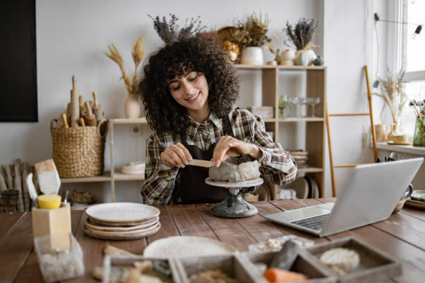 istock Young woman sculpting clay in home studio 2155607547
