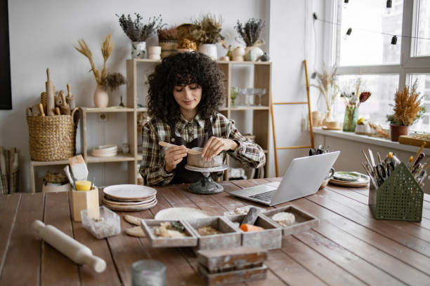 istock Young woman making pottery in cozy home studio 2155607553